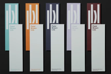 Five tall vertical paper samples in different colors with white typography against a dark background