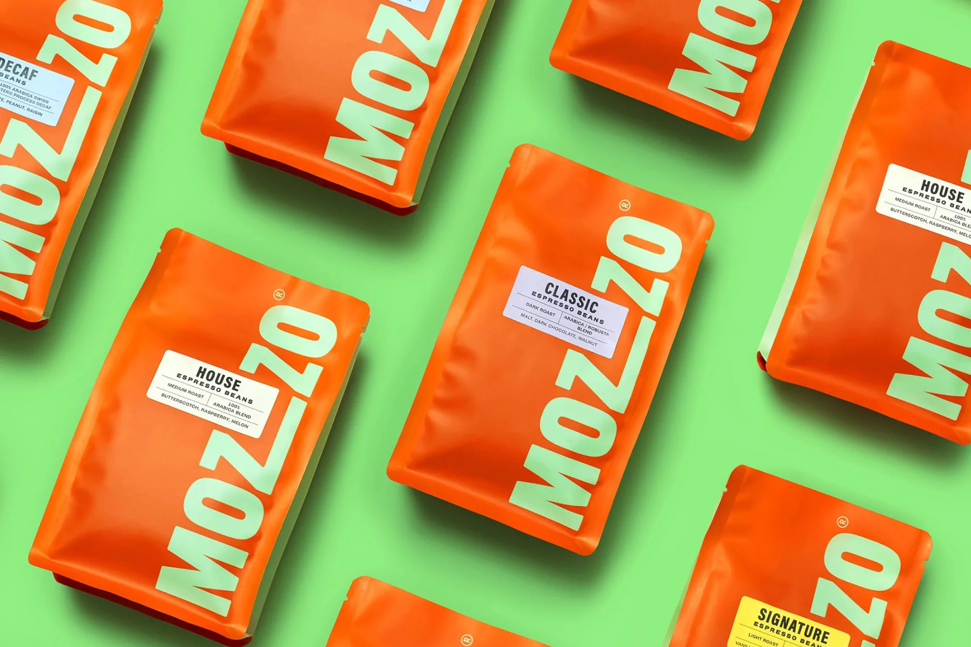 Overhead shot of Mozzo coffee bean bags arranged on a light green background, showcasing various roasts with label details.