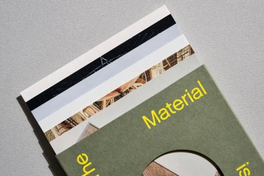 Close-up of printed paper material samples with green packaging and yellow typography by Mohawk, photographed by Henrik Kam.