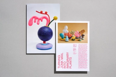 Two printed pages showing colorful paper sculptures and editorial typography against a textured grey background.