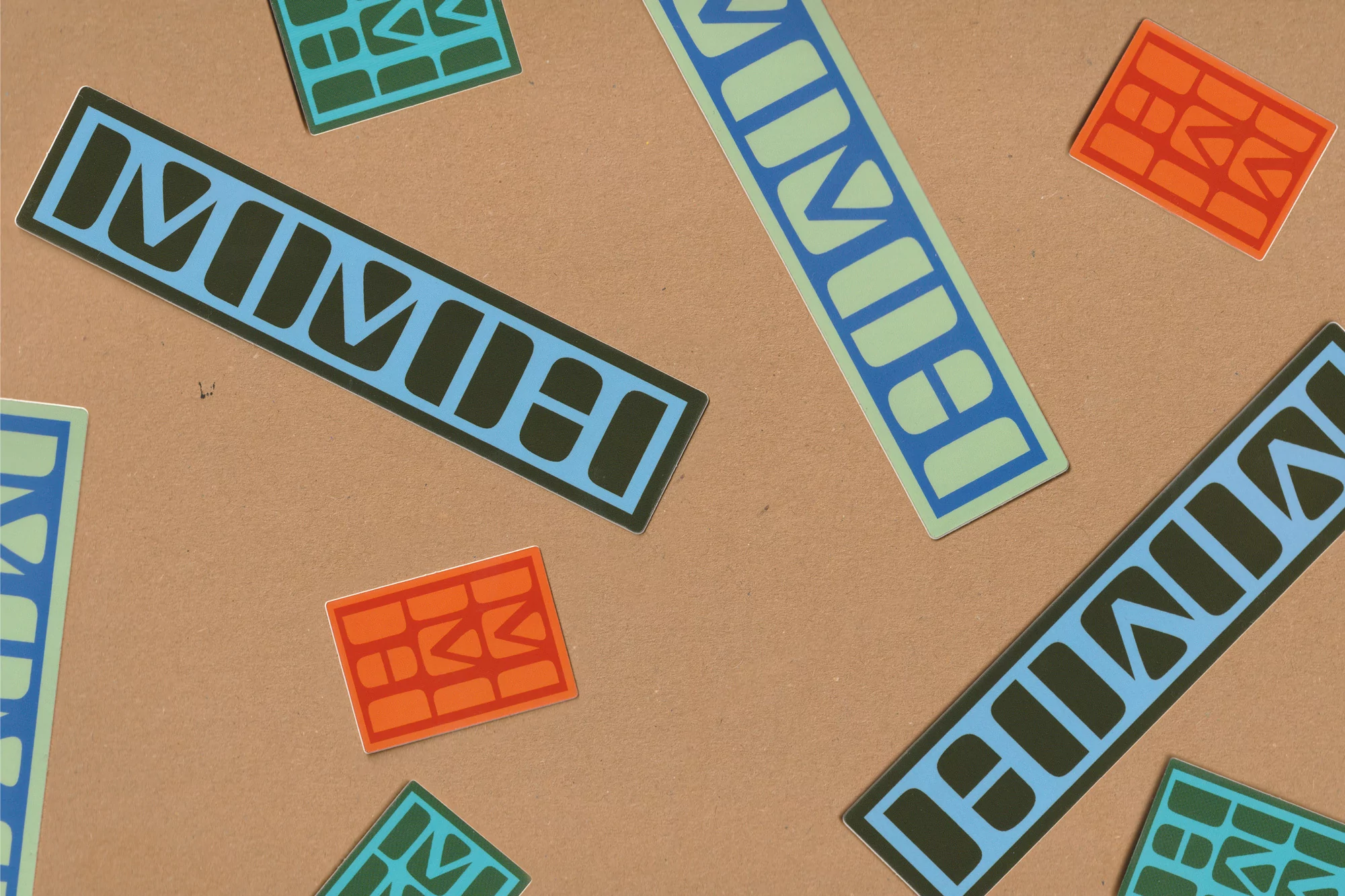 Colorful geometric stickers with unique designs and patterns, scattered across a textured tan background, creating a visually playful composition.