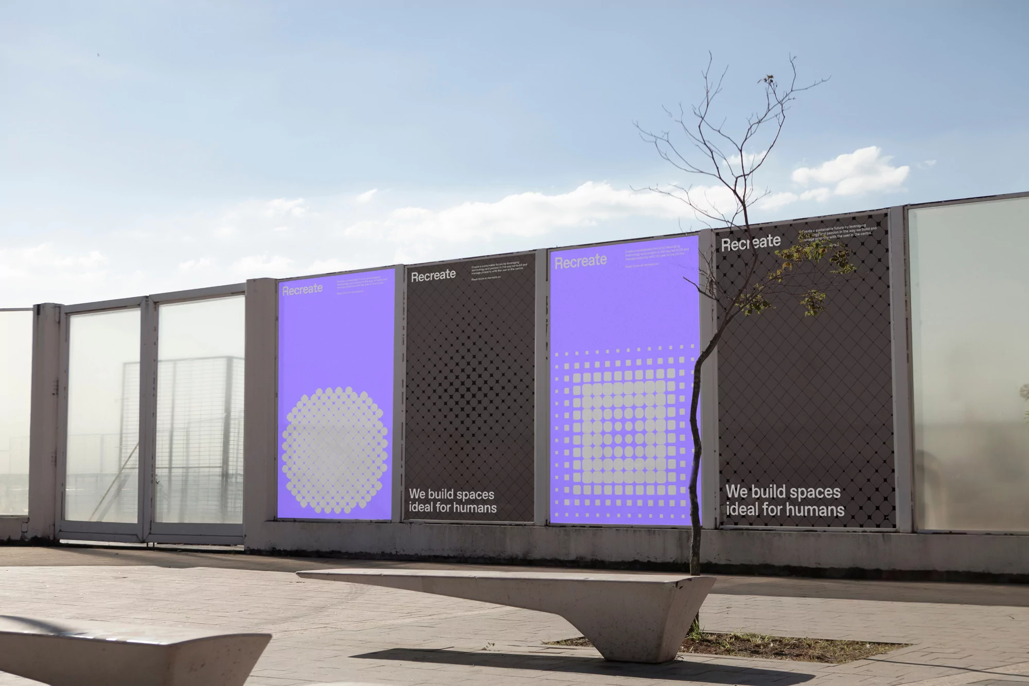 Outdoor posters on a concrete wall in a public space. The posters feature geometric designs in purple and black, with text about creating spaces.