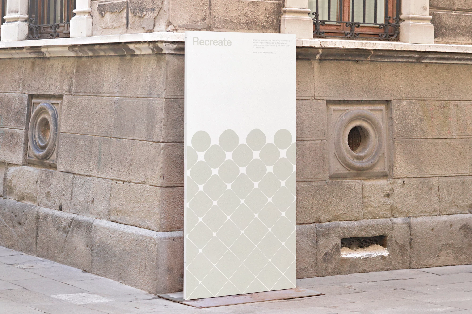 Vertical sign displaying brand identity for Recreate positioned against an aged stone building exterior corner.