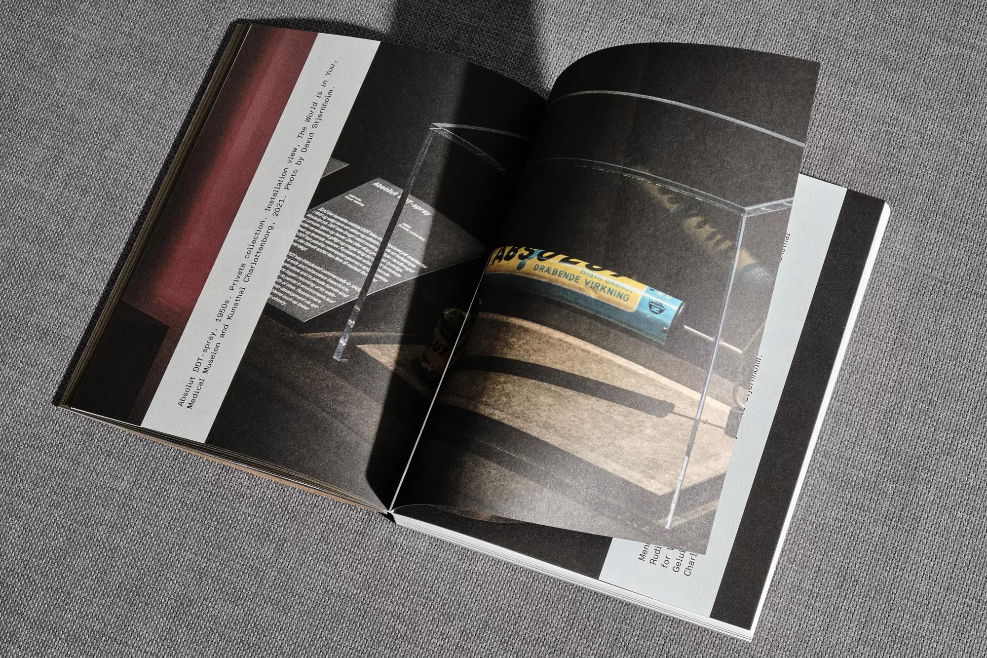 Open magazine spread features Absolut DOT-spray, 1960s in a glass display case at the Moderna Museet and Kestral Charlottenborg, 2021.