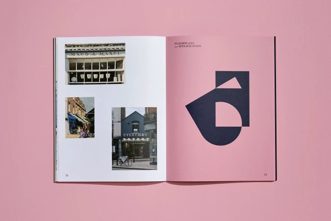 Open book displays photographs of building exteriors and an abstract graphic design on a pink background, showcasing architectural photography.