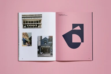 Open brochure featuring architectural photographs and geometric shapes against a solid pink background