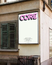 Outdoor building exterior featuring a white rectangular poster display for CORE with pink bubble typography