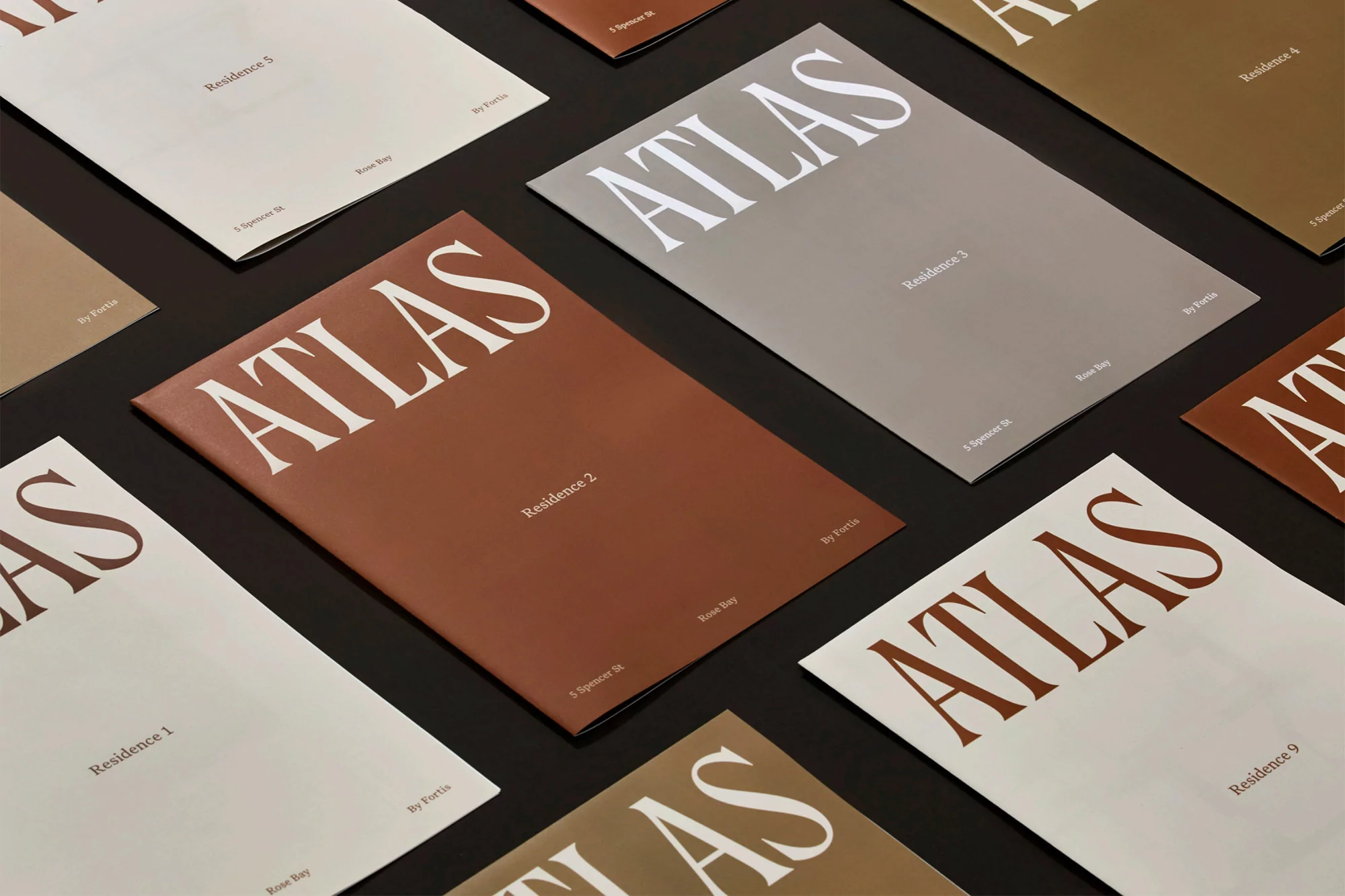 Several brochures with the word 'ATLAS' are arranged in a visually appealing layout on a dark background.