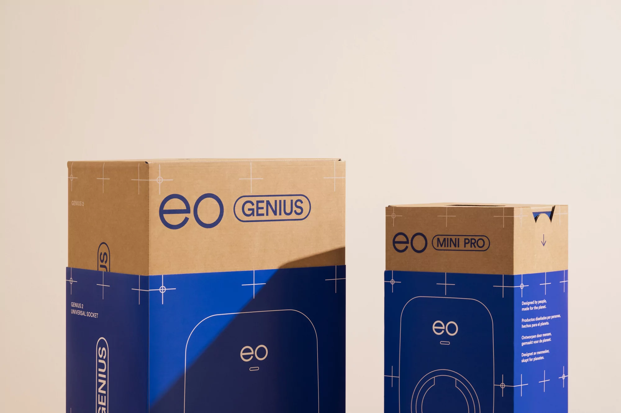 Two EO charging boxes, a larger Genius model and a smaller Mini Pro, stand side-by-side against a neutral backdrop in a product display.