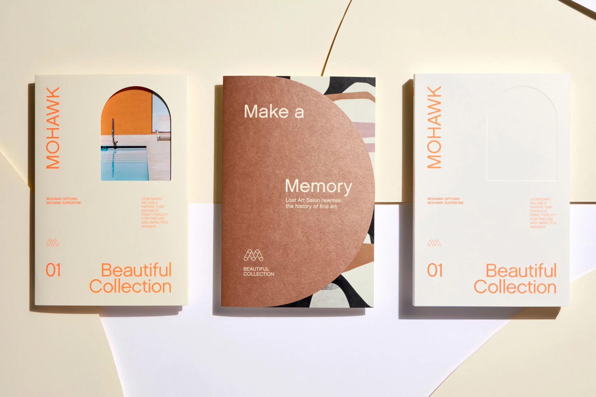 Three Mohawk paper sample books are arranged against a white backdrop, showcasing design elements and material quality.