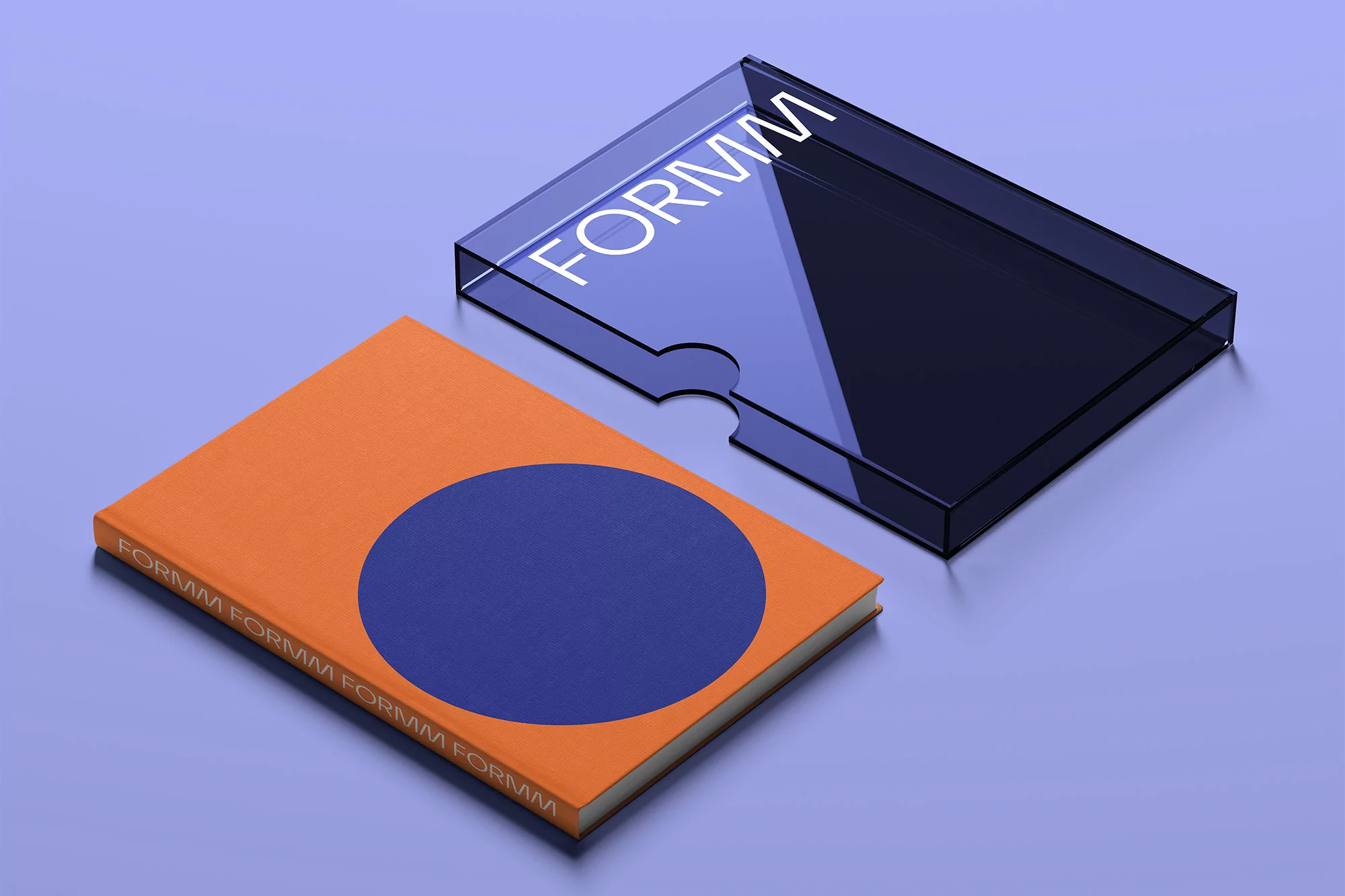 An orange book with a blue circle on the cover sits next to a clear acrylic box on a light blue surface, showcasing minimalistic design.