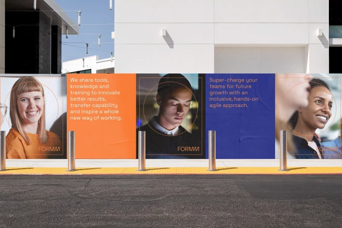 Building with posters of three smiling people of diverse backgrounds, promoting tools and training for future growth and innovation.