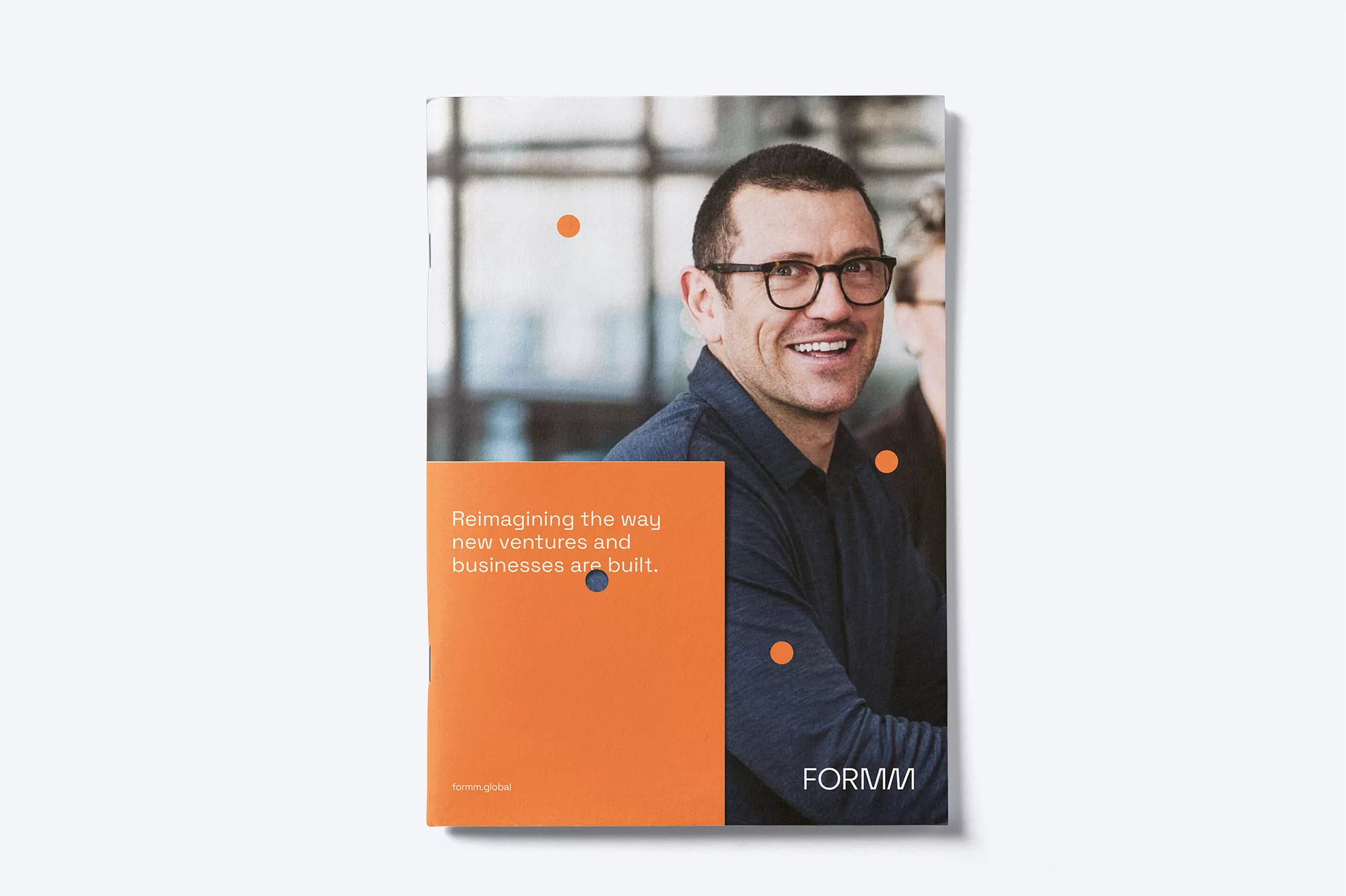 Close-up of a business magazine cover featuring a smiling man in glasses, with geometric design elements and the 'FORMM' logo.