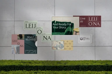 Collage of Leijona brand identity graphics and photography mounted on a pale stone wall above a green hedge.