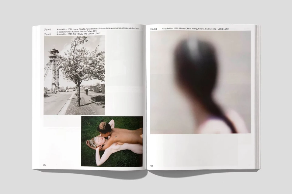 Open book spread displaying two photographs; one of a tower and tree, the other of a blurred figure. White background.