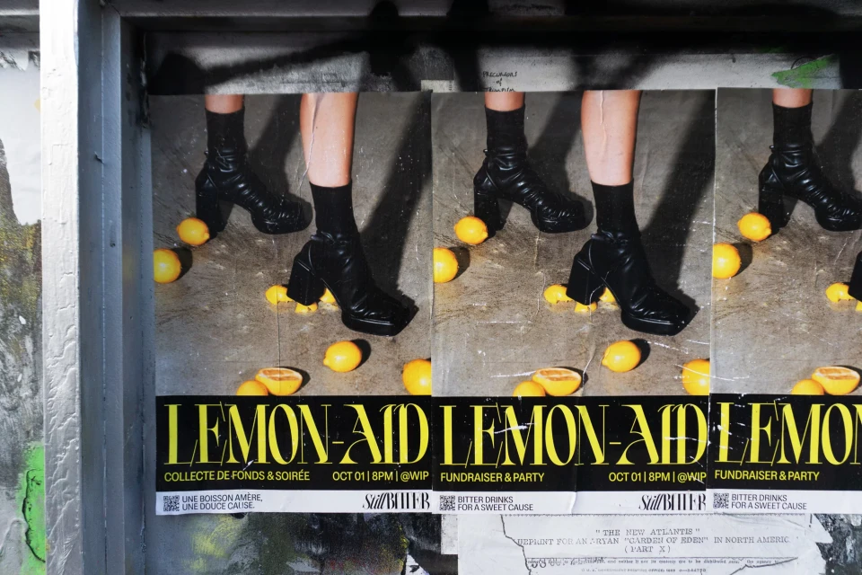 Close-up of a triptych poster showing legs with black socks and platform shoes surrounded by scattered lemons. Lemon-Aid text is prominent.
