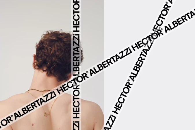 Rear view of a person with curly hair wearing gold necklaces against a white background with branded text overlays