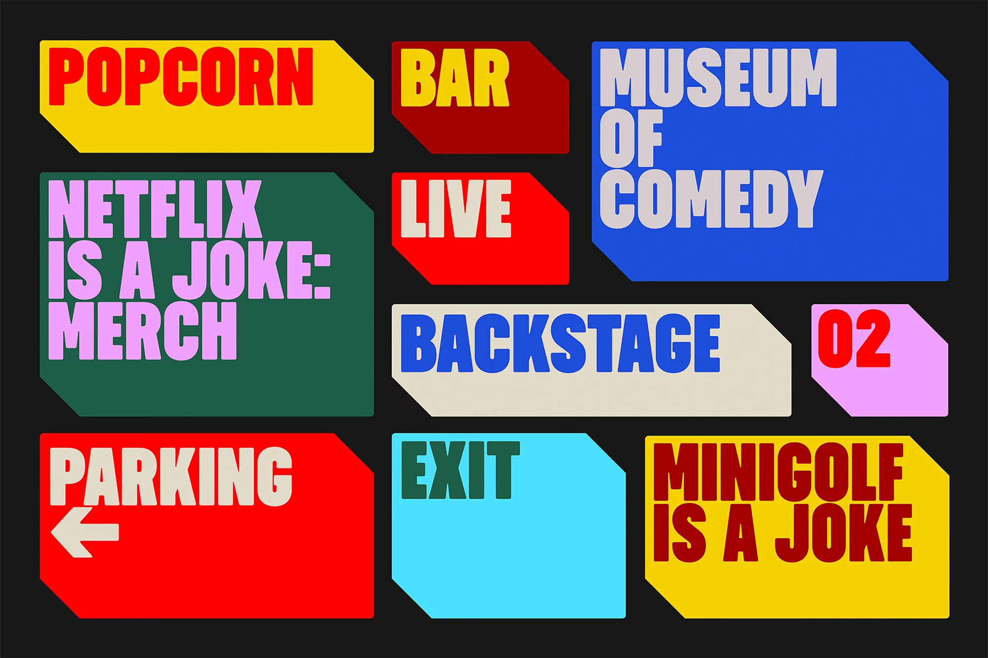 Colorful signage art installation featuring popcorn, bar, museum of comedy, Netflix is a joke, backstage, parking, exit, and minigolf themes.
