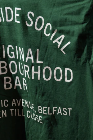 Close-up shot of dark green fabric featuring bold white typography branding for Southside Social bar in Belfast