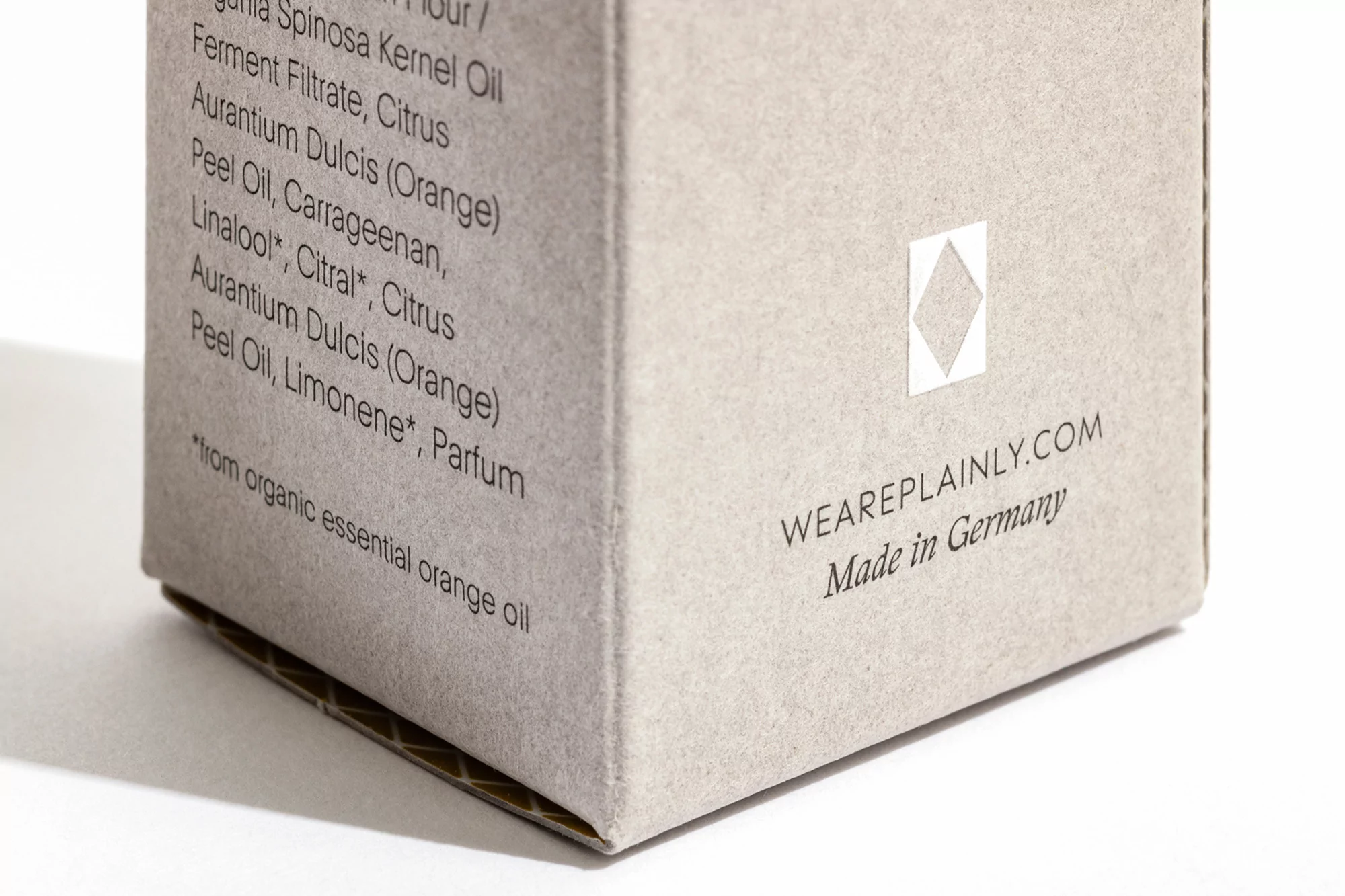 Close-up of a skincare product box featuring a list of ingredients, the brand's website, and 'Made in Germany' against a white backdrop.