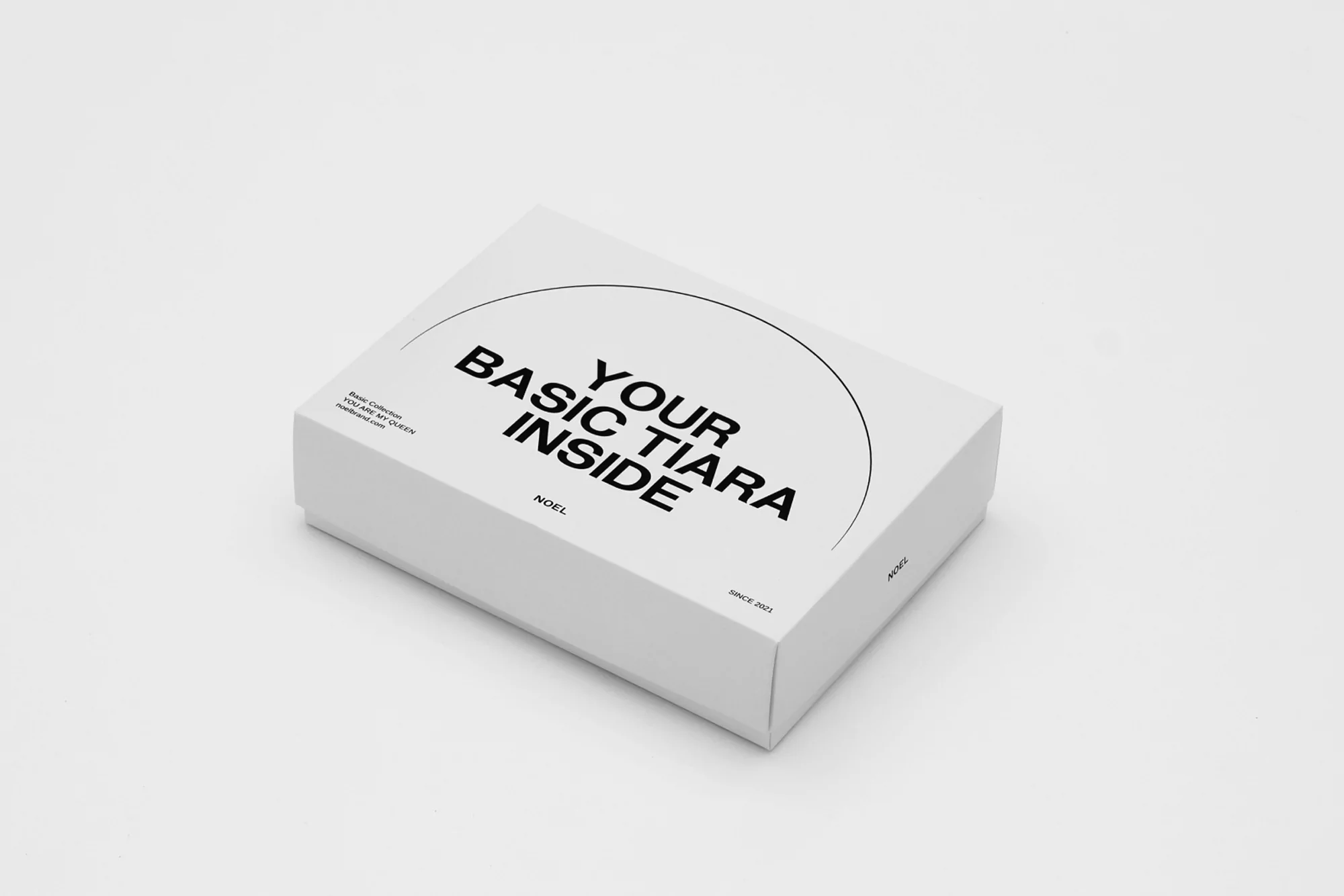Product shot of a white box with the words, 'Your Basic Tiara Inside' printed on the top, set against a clean white background.