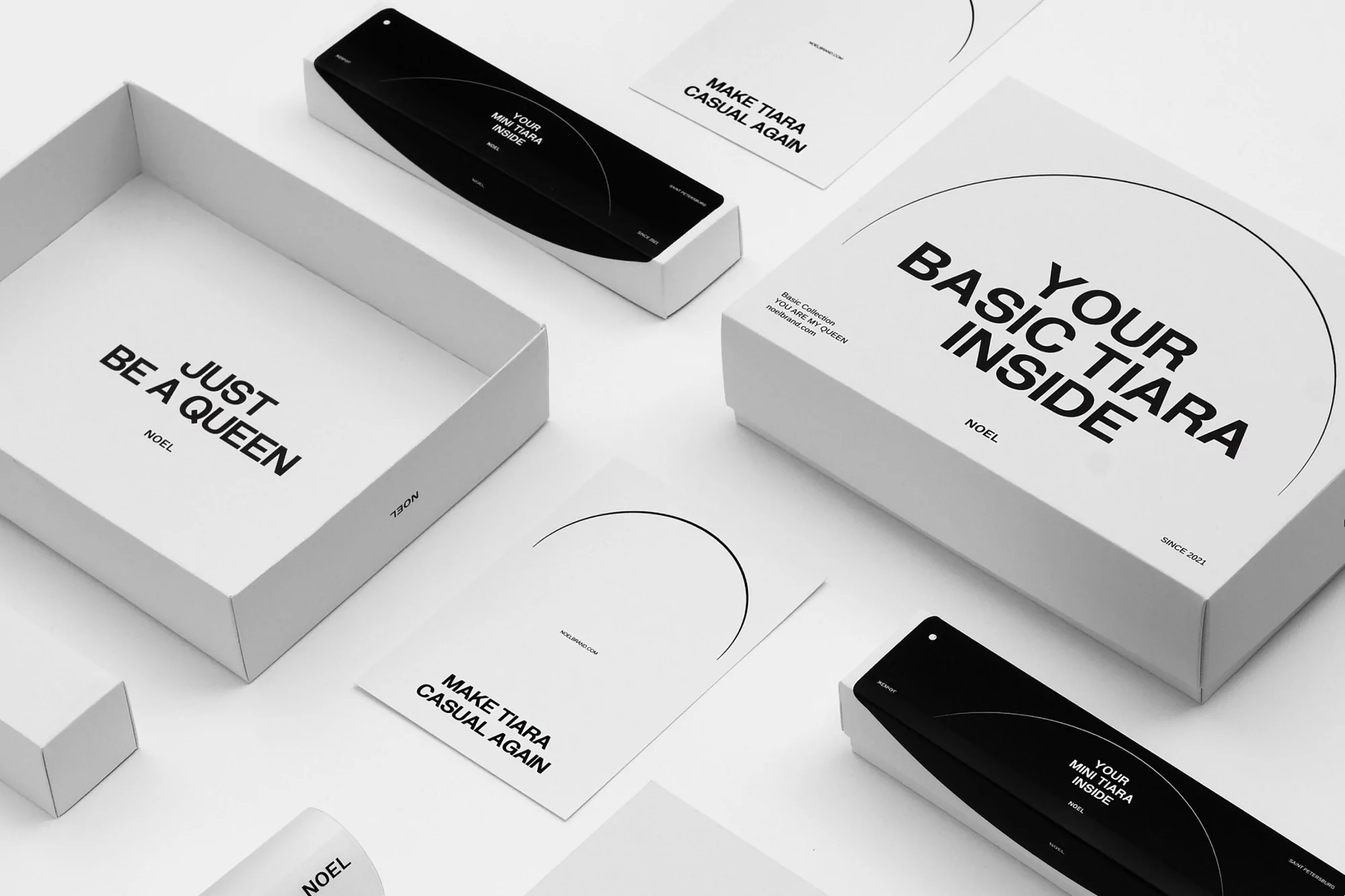 White boxes and cards with black text are arranged against a white backdrop, conveying a minimalist, modern aesthetic for product packaging.
