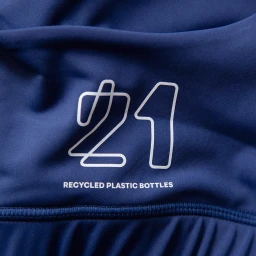 Close-up shot of a dark blue fabric surface featuring white graphic text reading 21 RECYCLED PLASTIC BOTTLES.