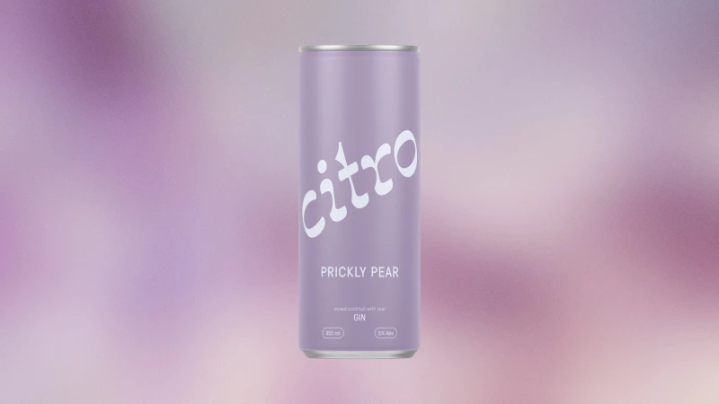 A single can of pear-flavored Citra brand seltzer beverage on a blurred background of soft purple tones in a studio setting.