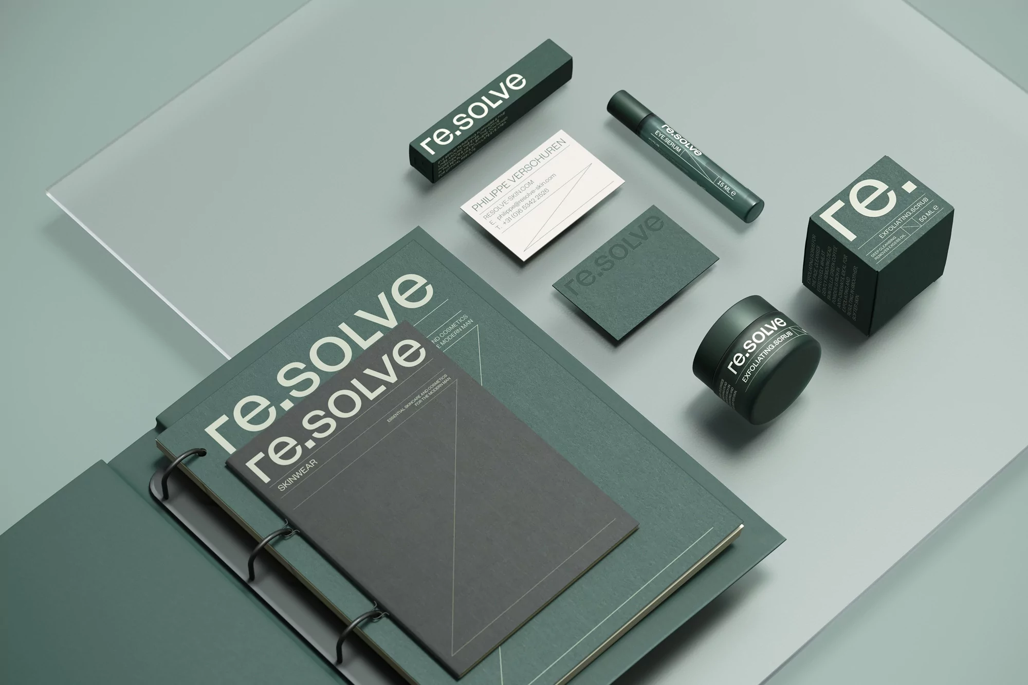 Close-up studio shot of re.solve skincare products including eye serum, exfoliating scrub, and marketing materials, set against a pale grey background.