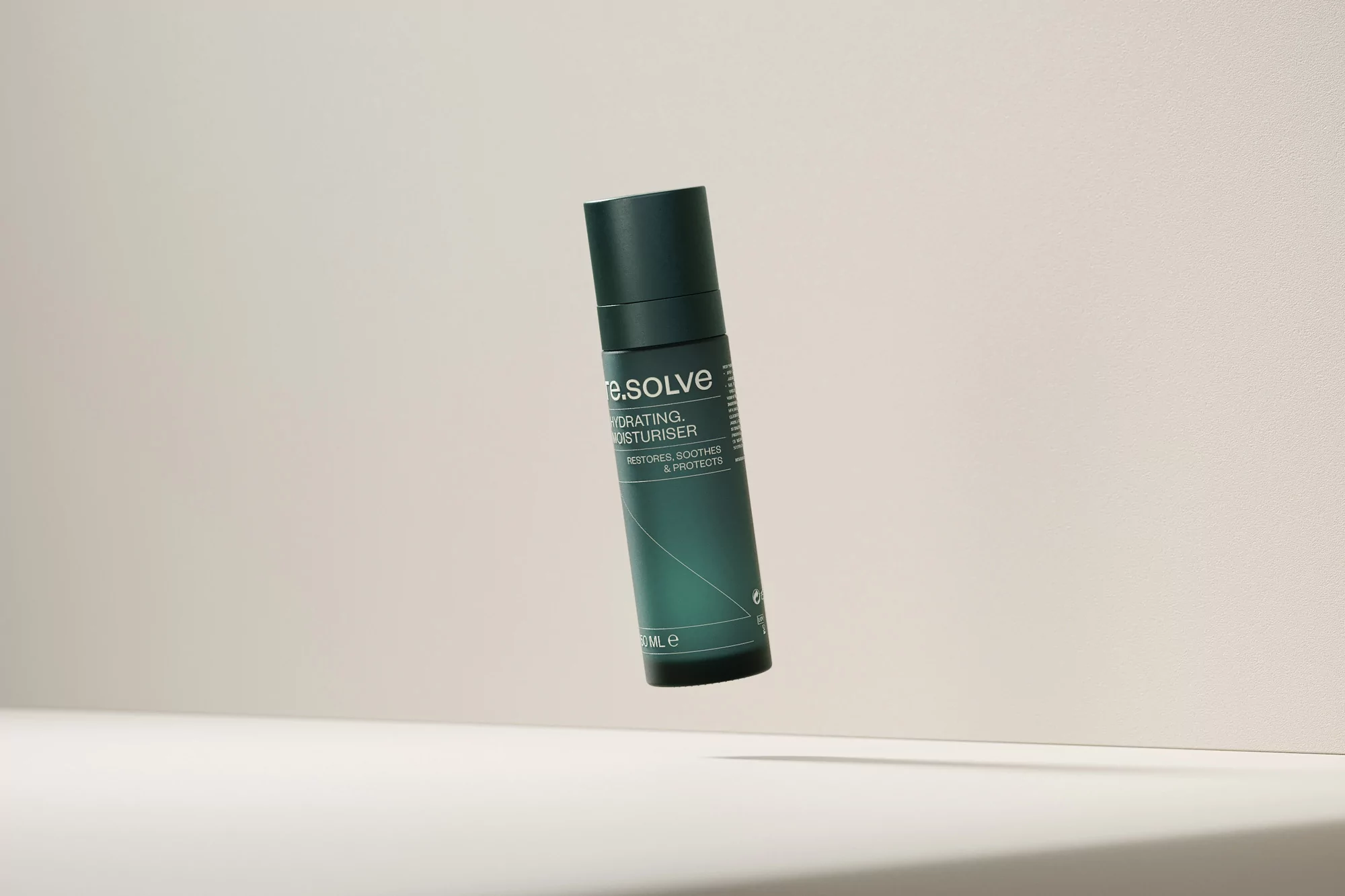 Dark green pump bottle of hydrating moisturiser on a beige background in a studio shot. Beauty product advertisement.