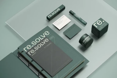 Flat lay of Re.solve cosmetics packaging, business cards, and branded stationery arranged on a pale green surface with a clear acrylic sheet