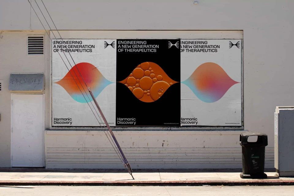 Outdoor posters on a white wall showcase a new generation of therapeutics with colorful abstract shapes and minimalist typography.