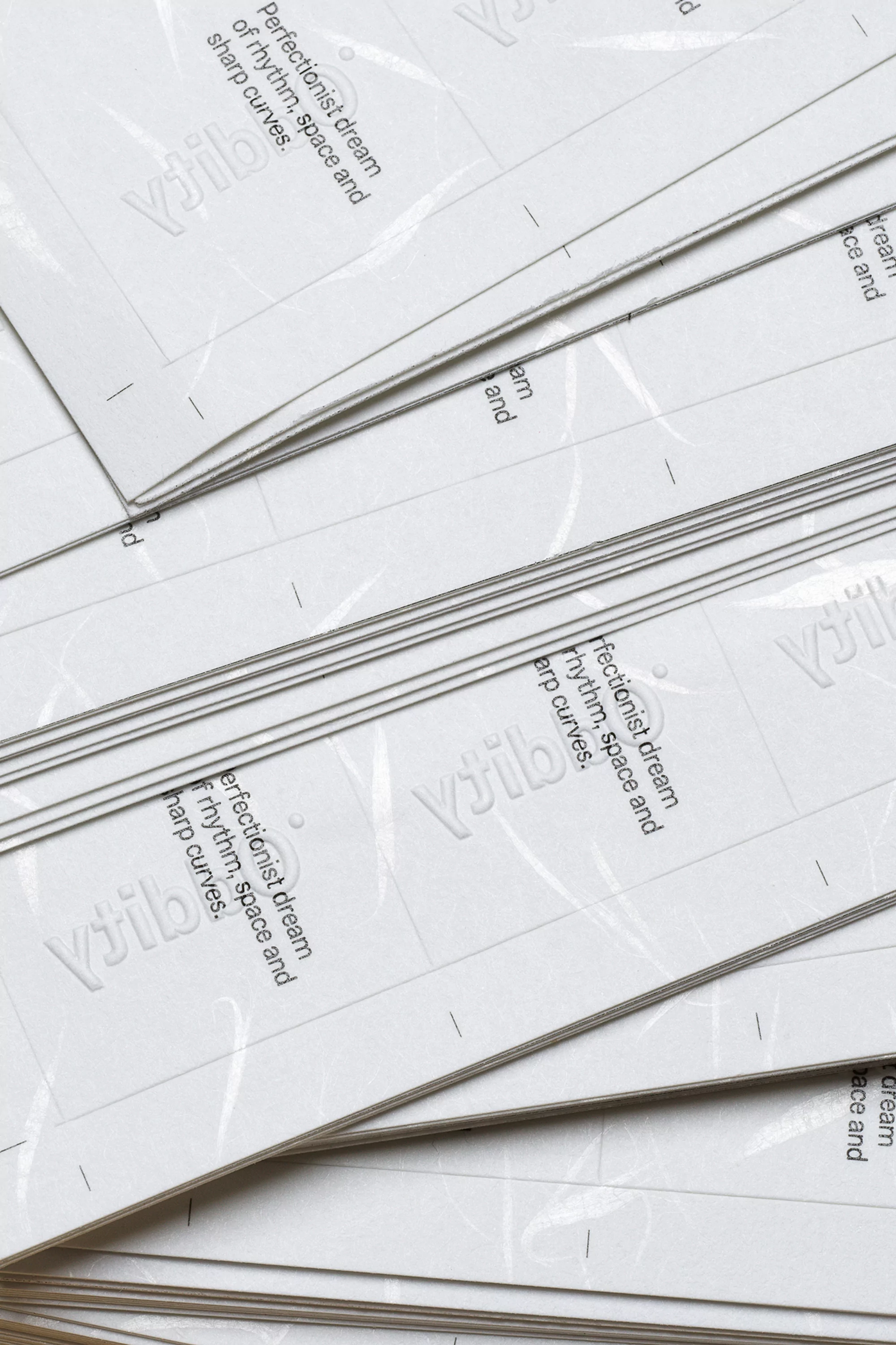 Close-up of white paper sheets with debossed text and graphics creating a subtle, textured pattern, suitable for backgrounds and overlays.