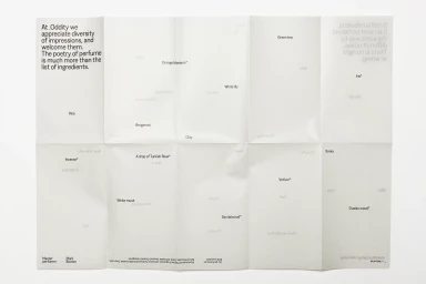 Folded white paper sheet with minimalist typographic layout and fragrance notes for Oddity brand identity