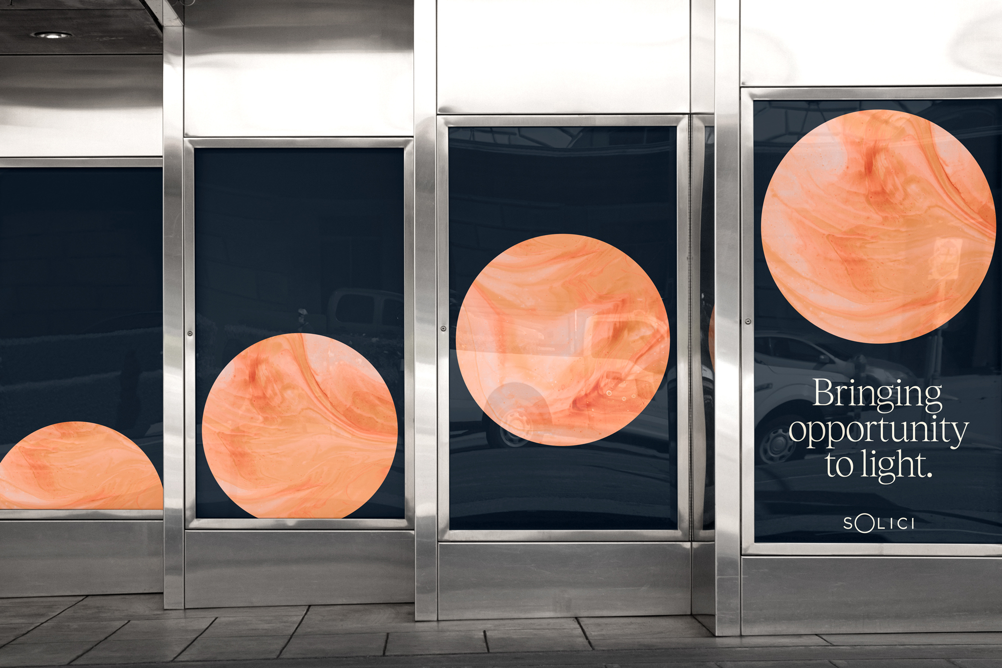 Modern advertisement in a public space featuring abstract circular designs and the text 'Bringing opportunity to light'.