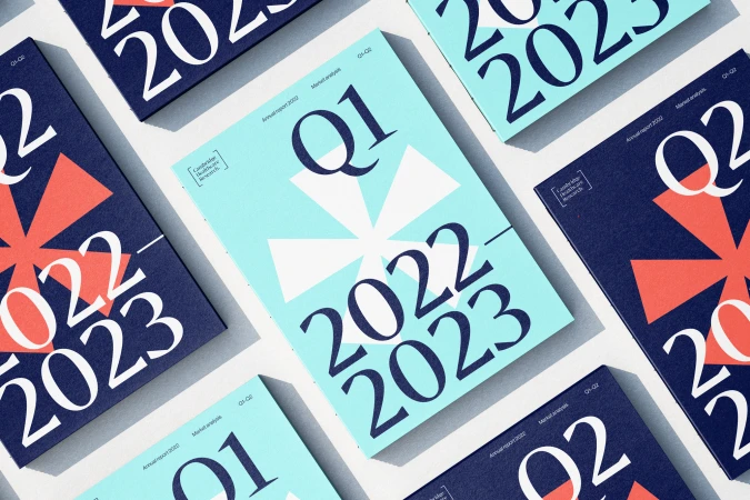 Several quarter reports for 2022 and 2023 are displayed in a flat lay with covers in blue and light blue, arranged on a white surface.