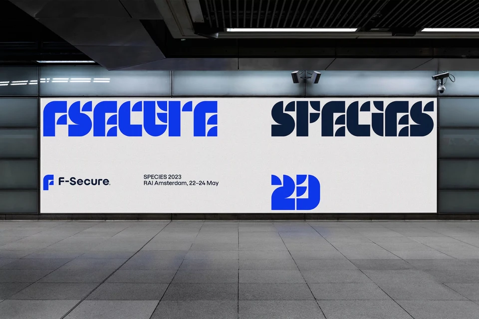 F-Secure cybersecurity billboard advertisement in a subway station, featuring bold typography, blue and white colors, promoting a 2023 event.