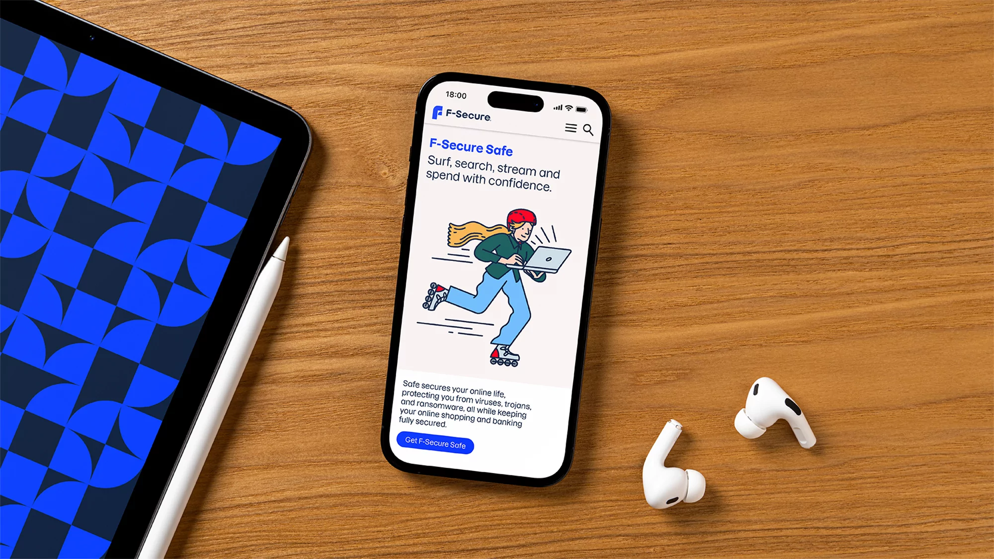Digital devices on a wooden table display the F-Secure Safe application: a smartphone showing an animated graphic with wireless earbuds.