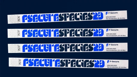 Four white wristbands with blue bold typography and F-Secure branding arranged horizontally on a dark background.
