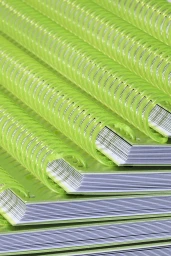 Close-up of a stacked arrangement of notebooks featuring vibrant green plastic spiral bindings.
