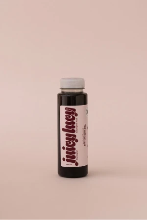 Juicy Lucy bottled beverage standing vertically against a pale neutral background with soft studio lighting