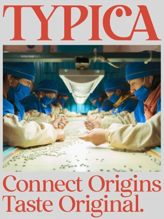 Workers in blue uniforms sort coffee beans along a conveyor belt in a bright facility under fluorescent lighting with the word 'TYPICA' above.