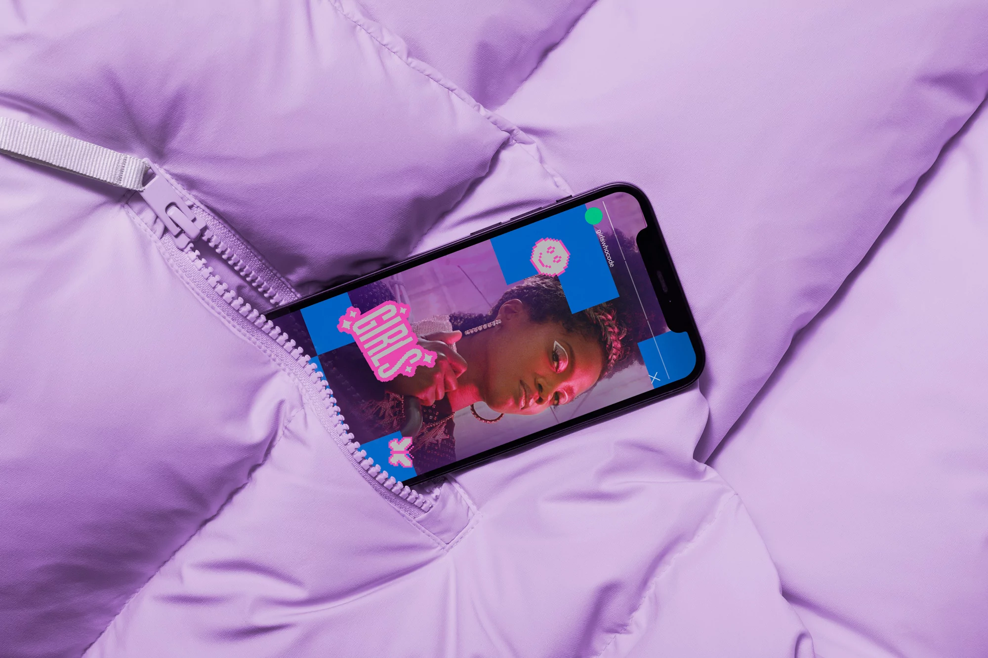 Close-up of smartphone displaying a woman's image, resting in the zipped pocket of a light purple puffer jacket, indoors.