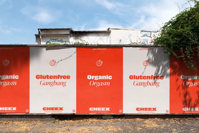 Outdoor wall features repeating red-and-white poster with slogans "Glutenfree Gangbang" and "Organic Orgasm" for the Cheex brand.