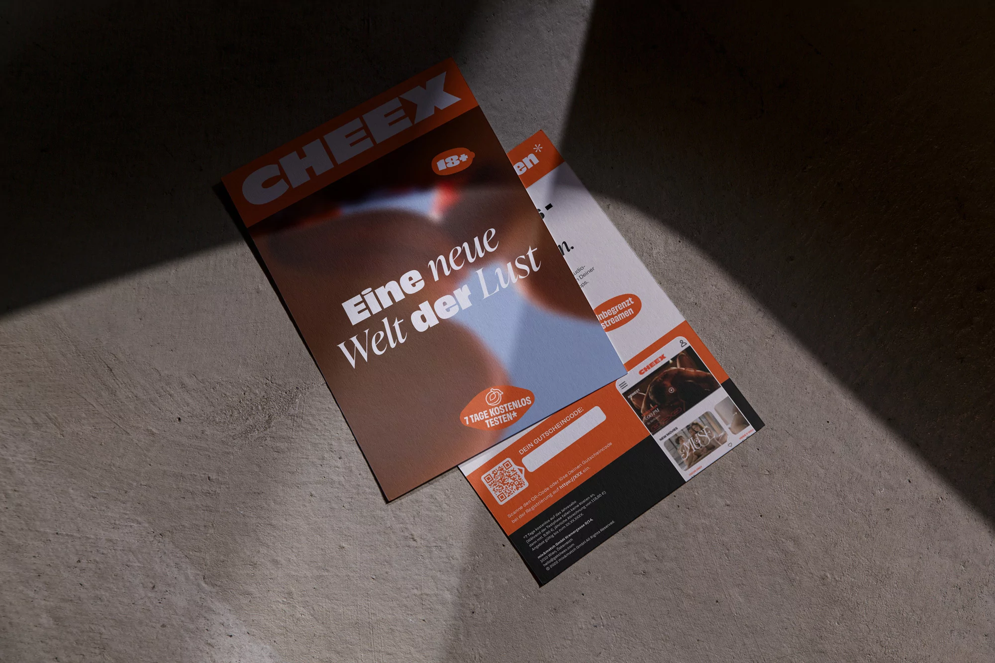 Two marketing flyers are displayed on a gray stone surface under hard, directional lighting creating shadows and promoting CHEEX.