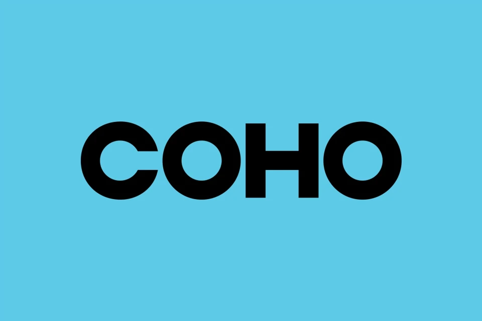 A bold typographic logo displaying the word 'COHO' in a clean sans-serif font, set against a vibrant light blue background.