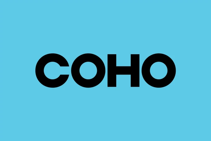 A bold typographic logo displaying the word 'COHO' in a clean sans-serif font, set against a vibrant light blue background.