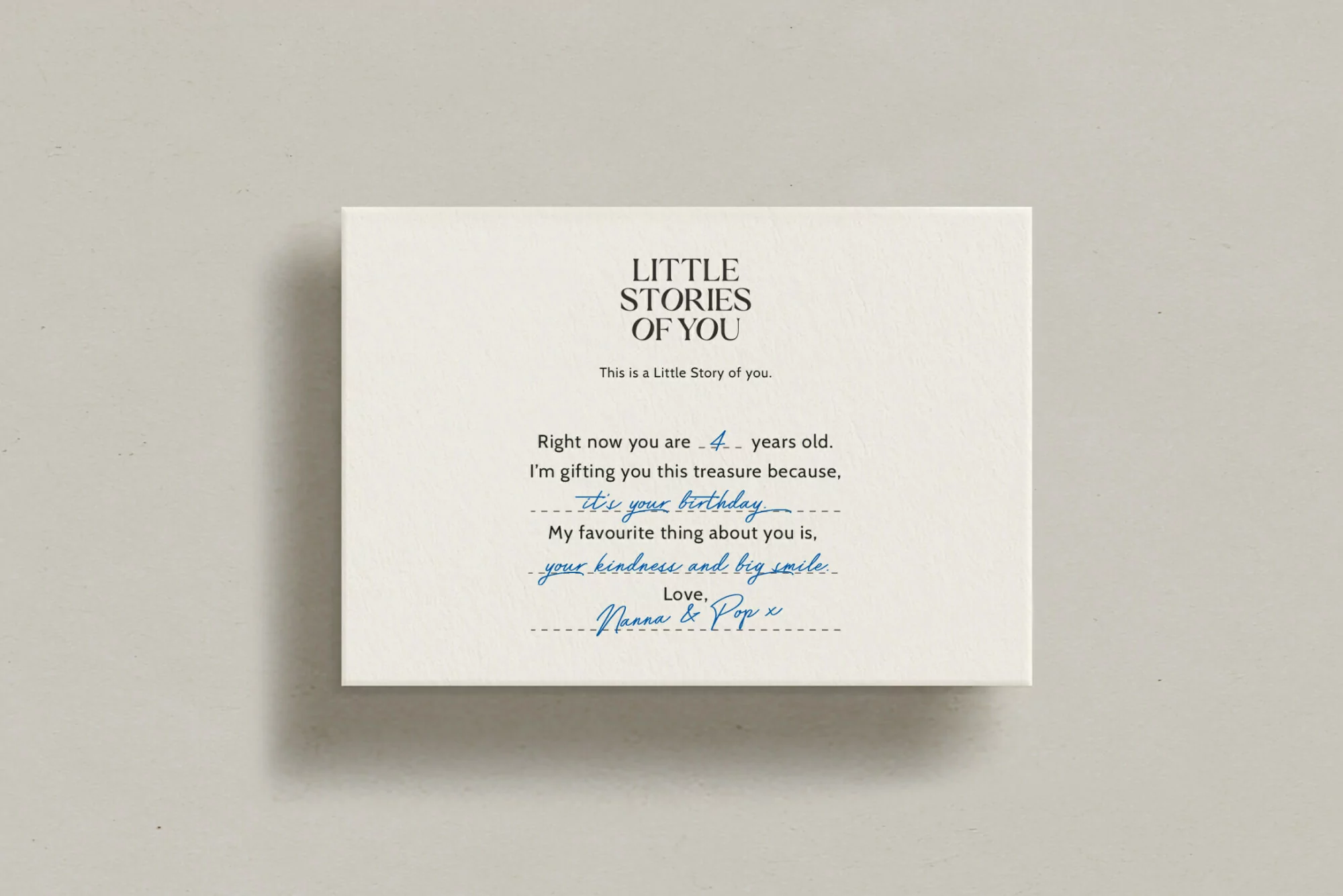 Close-up of a white box with black and blue handwritten-style text, featuring a personalized story and birthday message.