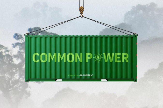 Green shipping container suspended by crane against a cloudy sky with trees, featuring text "Common Power Powered by Greenpeace".