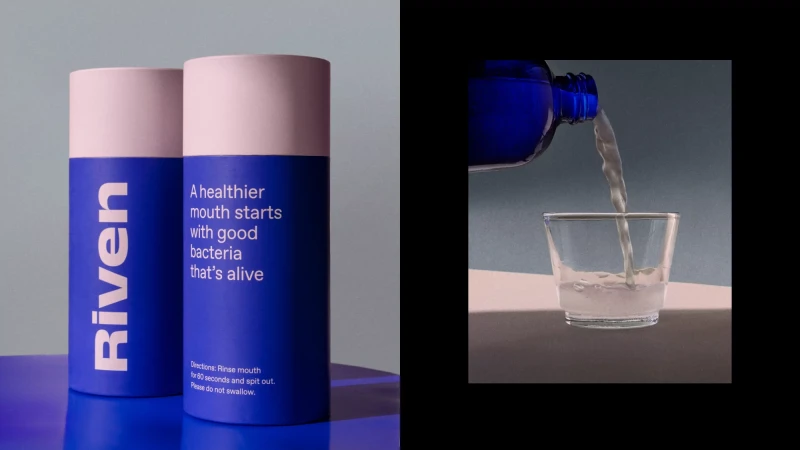 Two blue and white cylindrical product packaging containers next to a glass receiving poured liquid